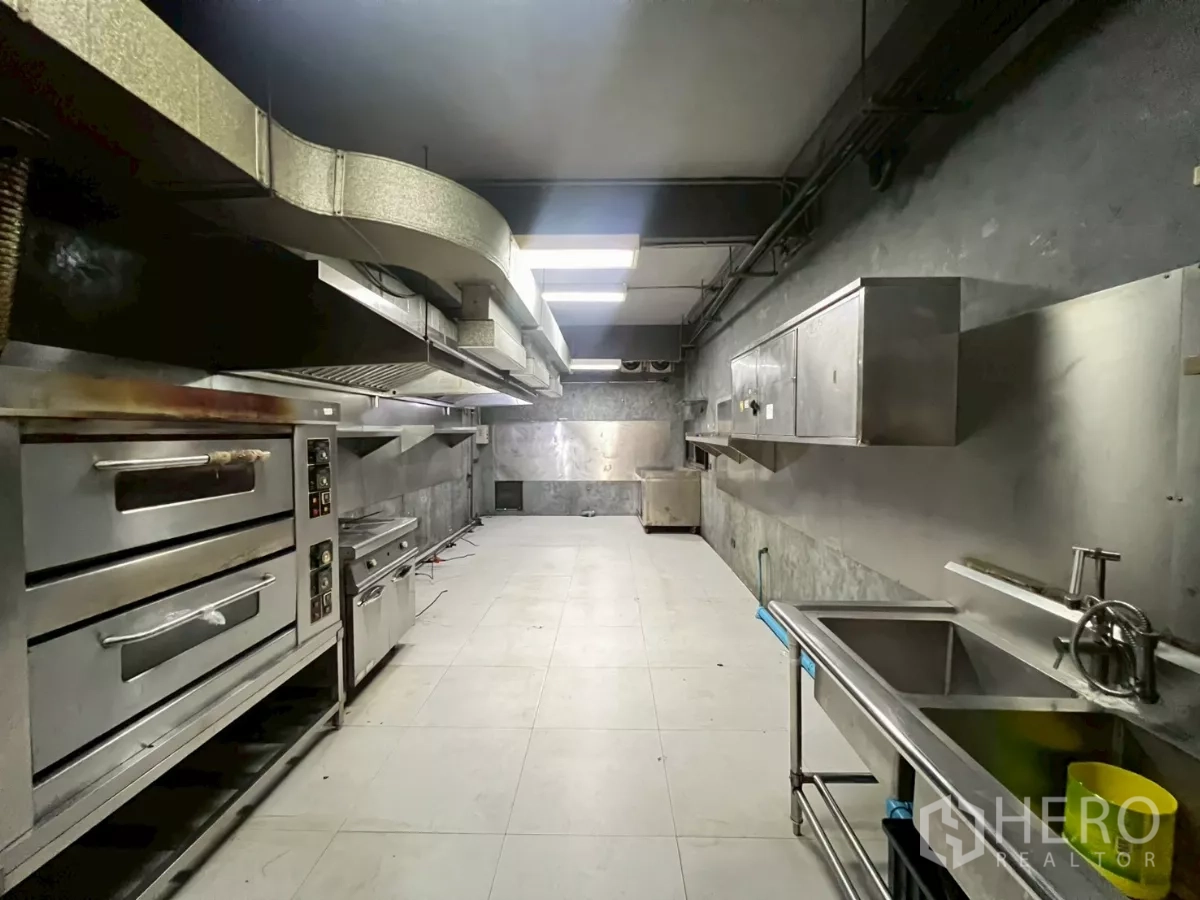 零售空间 出租 - 商用厨房配不锈钢烤箱、排烟罩、水槽与操作台。