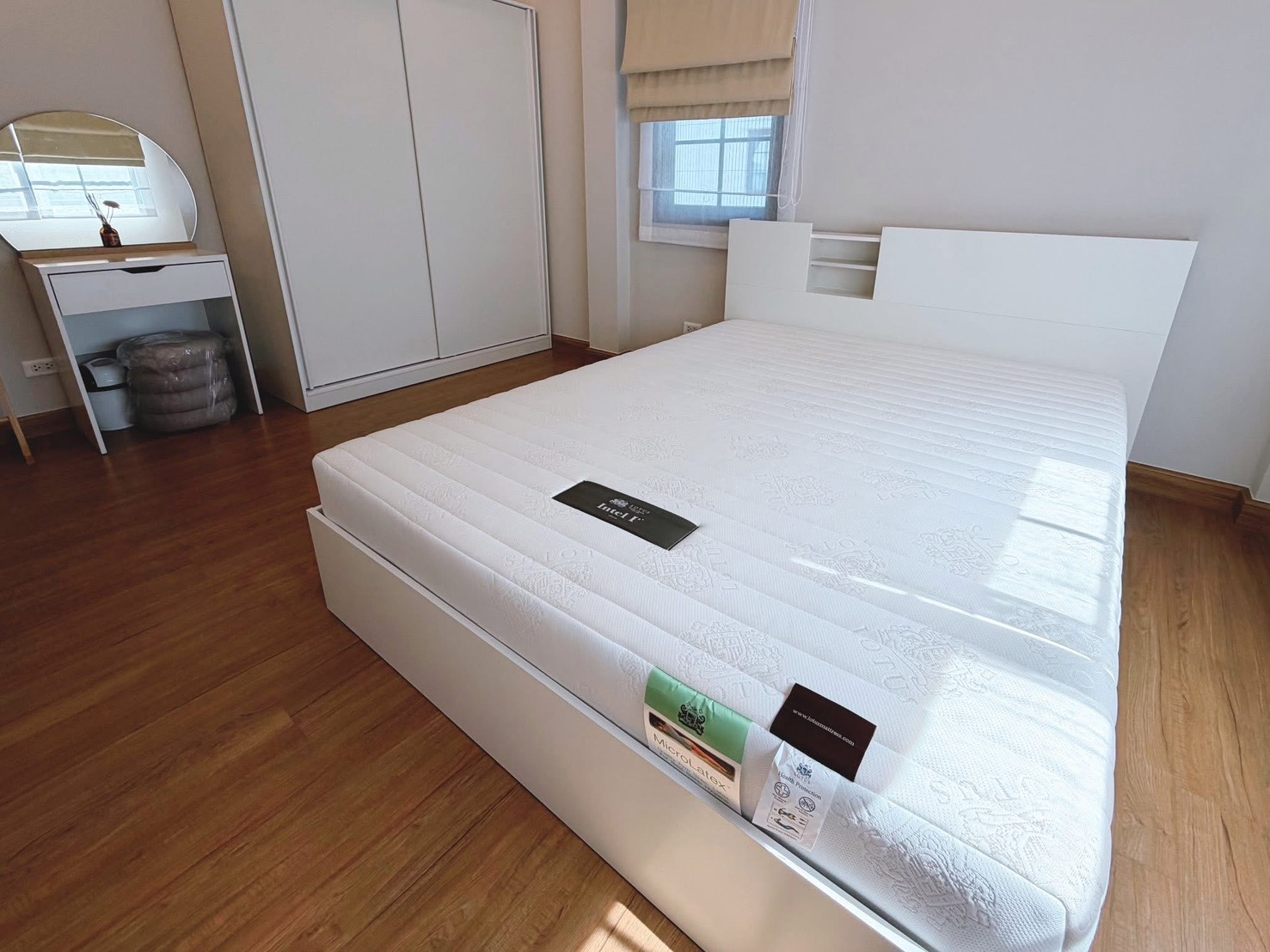 独立式住宅 出租在Bang Phli, Samut Prakan - 采光充足的卧室，白色床，推拉衣柜、梳妆台与木地板。