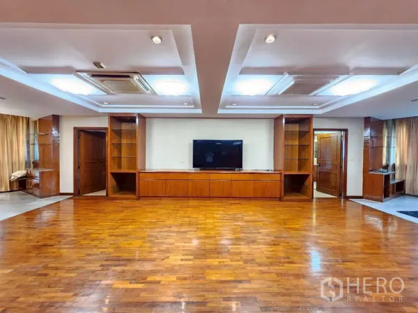 คอนโด ให้เช่าในKhlong Toei, Bangkok - พื้นที่นั่งเล่นขนาดใหญ่ ฝ้าหลุม ทีวีและชั้นวางล้อมด้วยผนังไม้โทนอุ่น