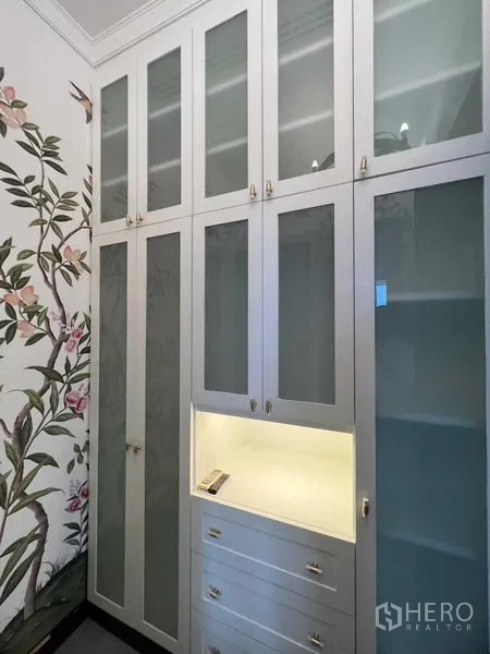 公寓 出售在Khlong Toei, Bangkok - 高挑白色定制衣柜，磨砂玻璃门与花卉墙纸。
