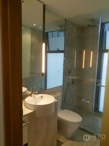 Condominium for rent in Sathon, Bangkok - Second bathroom with rain shower, glass enclosure and modern fixtures.