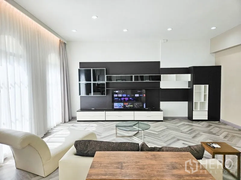 Townhouse for rent in Yan Nawa, Bangkok - Living area with built-in shelving and media cabinet under recessed lighting.