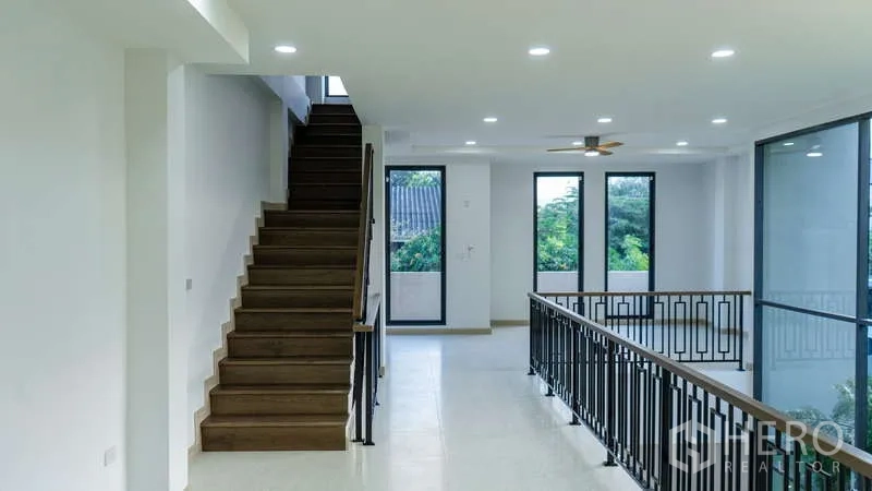 Detached House for rent or sale in Suan Luang, Bangkok - Wide stair landing with black metal balustrade and large windows