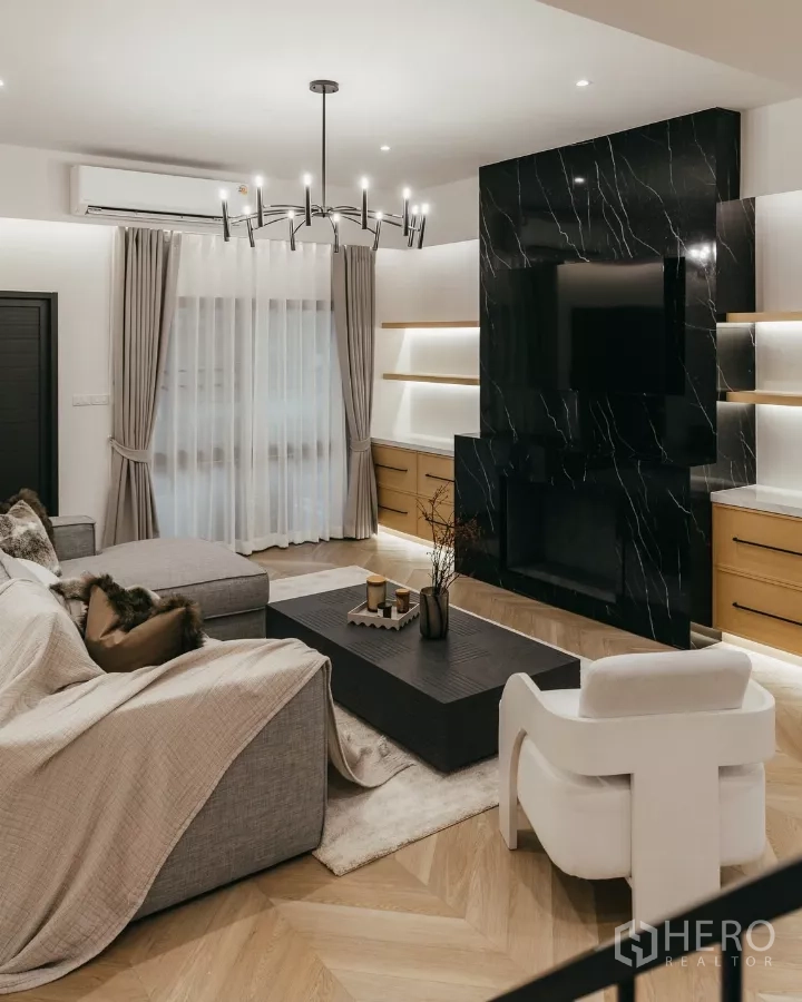 联排别墅 出租在Watthana, Bangkok - 瓦他那联排别墅客厅，黑色大理石电视墙与嵌入式柜体和吊灯。