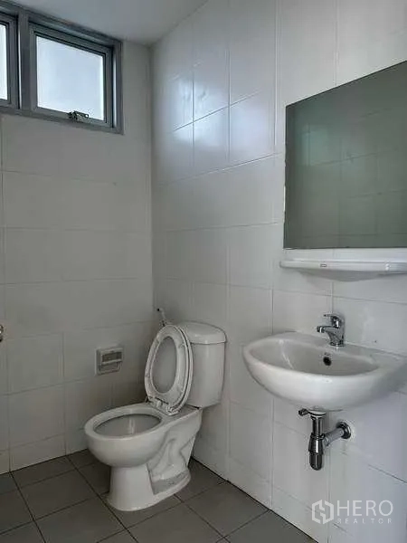 Factory for rent in Bang Sao Thong, Samut Prakan - Clean restroom with toilet, sink, mirror and white tiled walls.