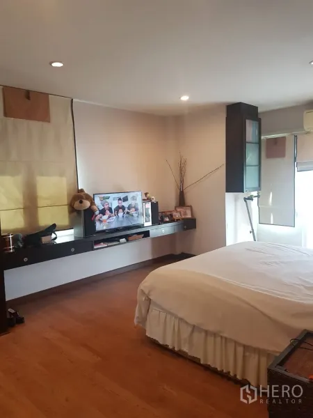 บ้าน ขายในLat Krabang, Bangkok - ห้องนอนใหญ่กว้าง พื้นไม้ เตียงคู่ โต๊ะยาวแขวนผนัง พร้อมทีวี