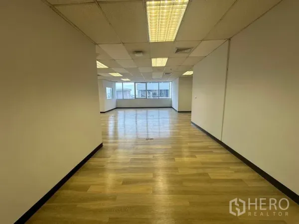 办公空间 出租在Phra Khanong, Bangkok - 走廊视角的开放办公室，木地板、网格天花与采光窗户。