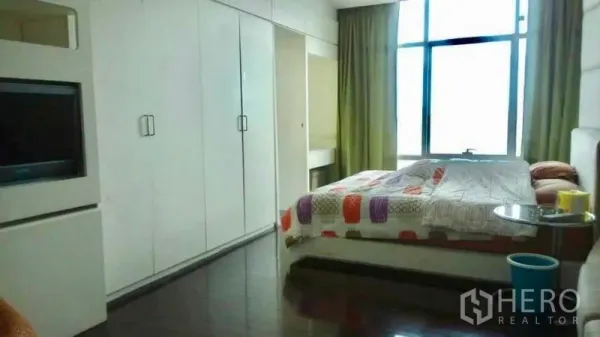 Condominium for sale in Bang Rak, Bangkok - Bright bedroom with floor-to-ceiling window, long built-in wardrobes and a double bed.