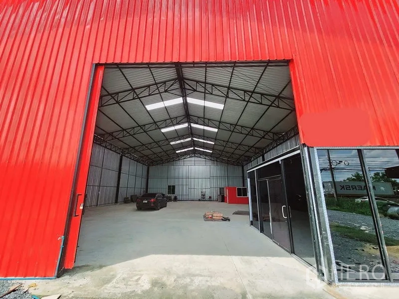 货栈 出租在Sam Phran, Nakhon Pathom - 红色大推拉门与玻璃入口相连，通向仓库内部。