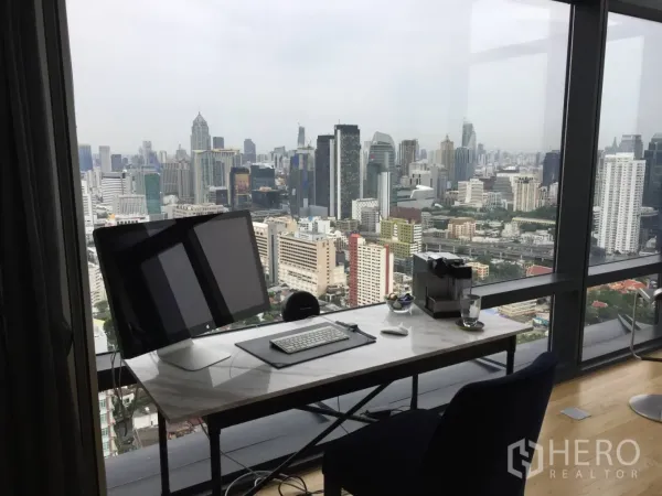Condominium for rent or sale in Ratchathewi, Bangkok - Work-from-home desk by the window overlooking the Bangkok cityscape.