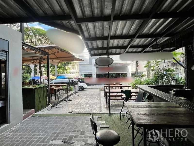 零售空间 出租在Watthana, Bangkok - 带顶棚的吧台座位，面向庭院与街道入口，设多组桌椅。