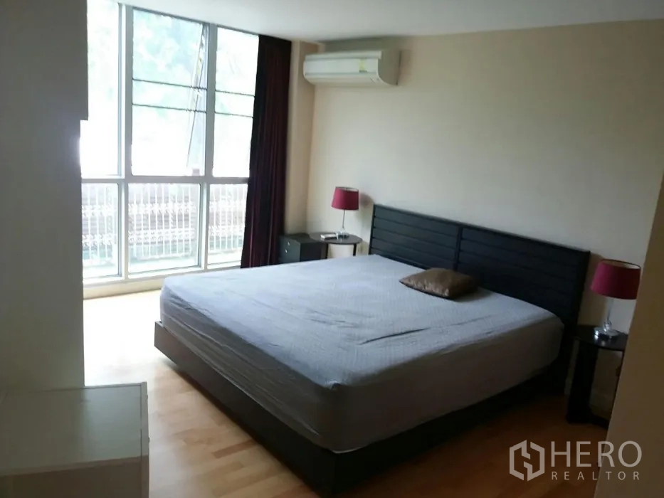 คอนโด ให้เช่าในPhaya Thai, Bangkok - ห้องนอนโปร่งสว่างพร้อมเตียงคิงไซส์ โต๊ะข้าง เตาแอร์ และหน้าต่างแบบเต็มผนัง