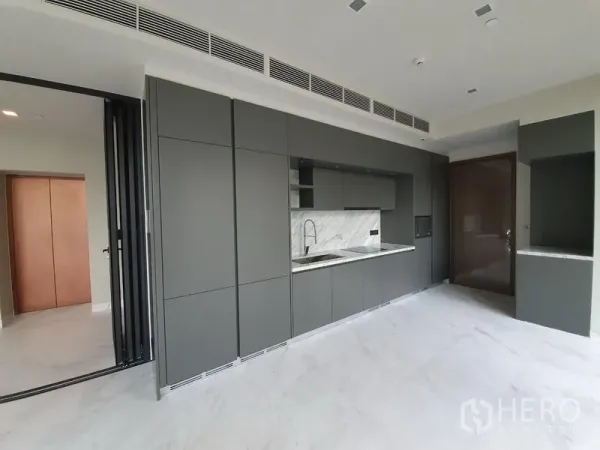 Condominium for rent in Watthana, Bangkok - Sleek matte-grey built-in kitchen with stone backsplash and integrated storage.
