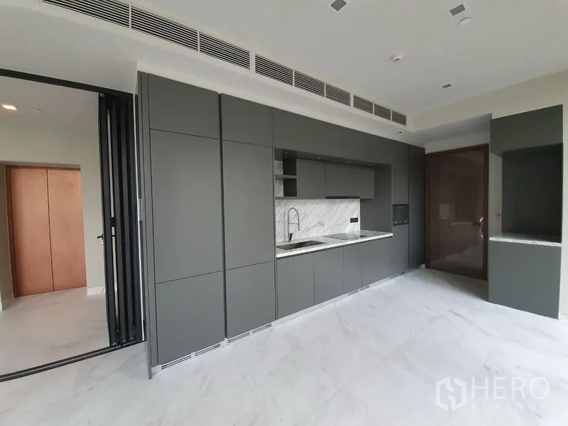 Condominium for rent in Watthana, Bangkok - Sleek matte-grey built-in kitchen with stone backsplash and integrated storage.
