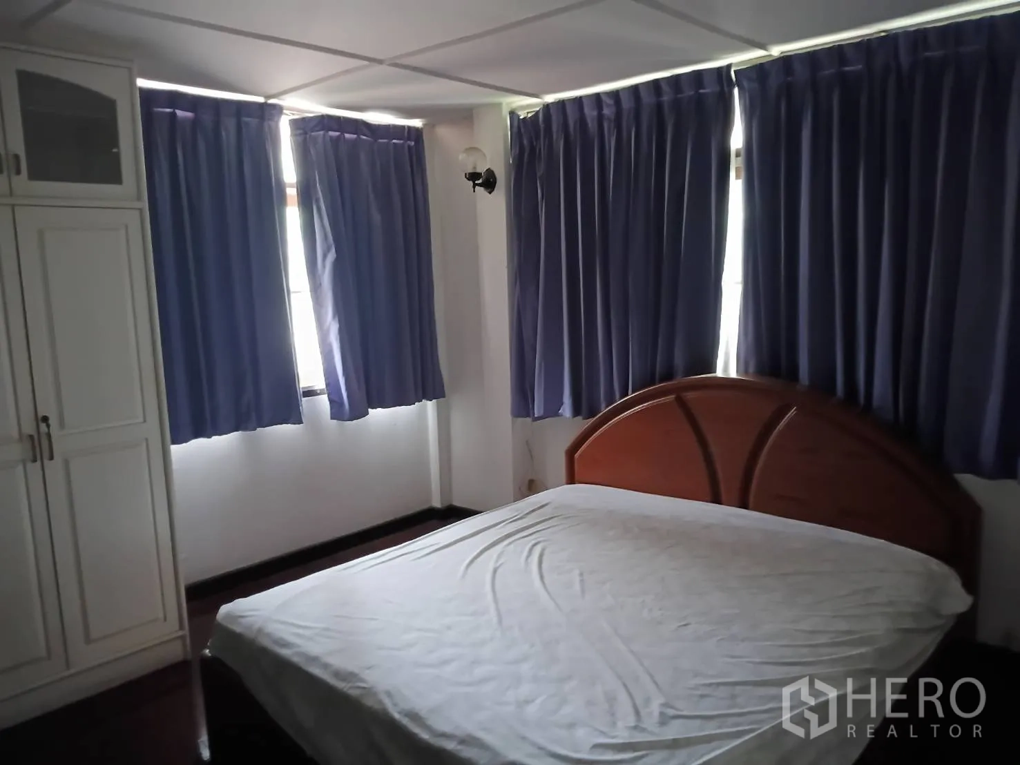 Detached House for sale in Watthana, Bangkok - Bedroom with bed, wardrobes, and multiple windows with dark curtains.