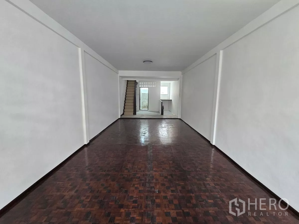 店屋 出租在Watthana, Bangkok - 开放式零售空间，木地板延伸至楼梯与服务区