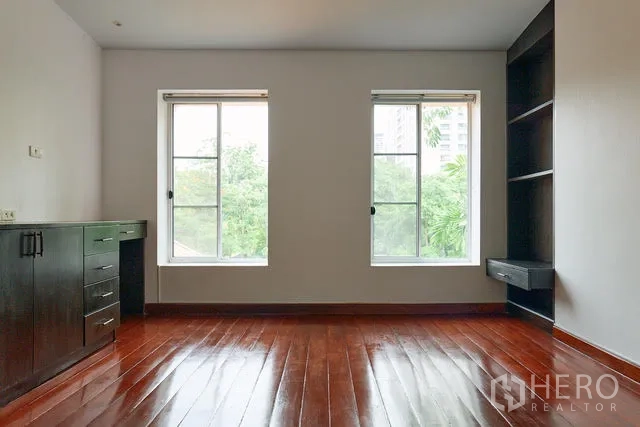 บ้าน ให้เช่าในWatthana, Bangkok - ห้องนอนโล่ง พื้นไม้เงา หน้าต่างคู่ และชั้นบิลท์อิน