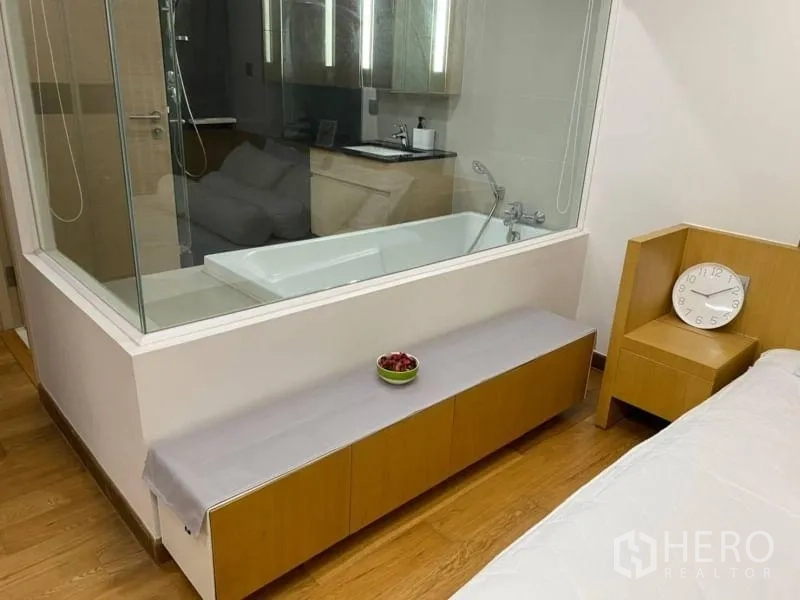 คอนโด ให้เช่าในWatthana, Bangkok - อ่างอาบน้ำหลังผนังกระจกติดกับม้านั่งยาวและหัวเตียงบิลต์อิน