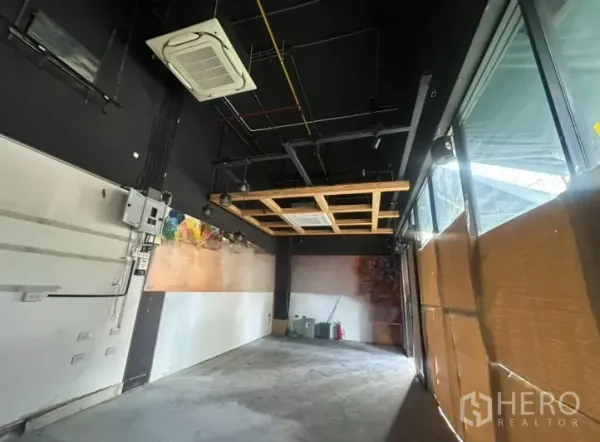 พื้นที่ขายปลีก ให้เช่า - ภายในร้านเพดานสีดำแบบเปิด โคมไฟราง แอร์คาสเซ็ต และกระจกเต็มความสูง