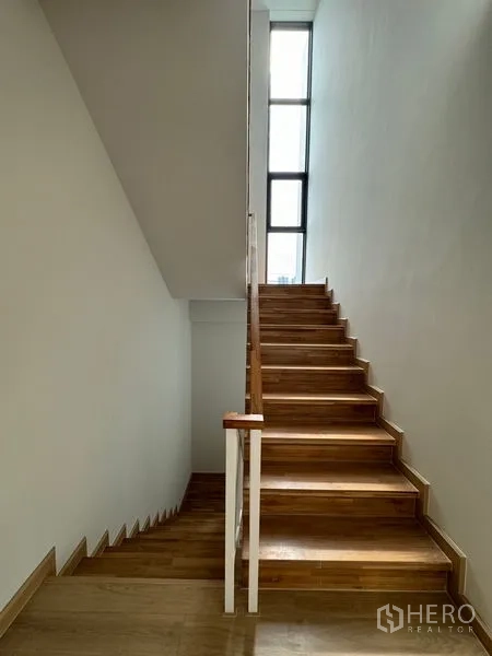 Home Office for rent in Pak Kret, Nonthaburi - Stairwell with natural light from a tall window and timber steps