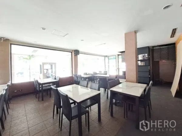 Retail Space for rent - Open dining area with tiled floors, square tables and wraparound glazing.