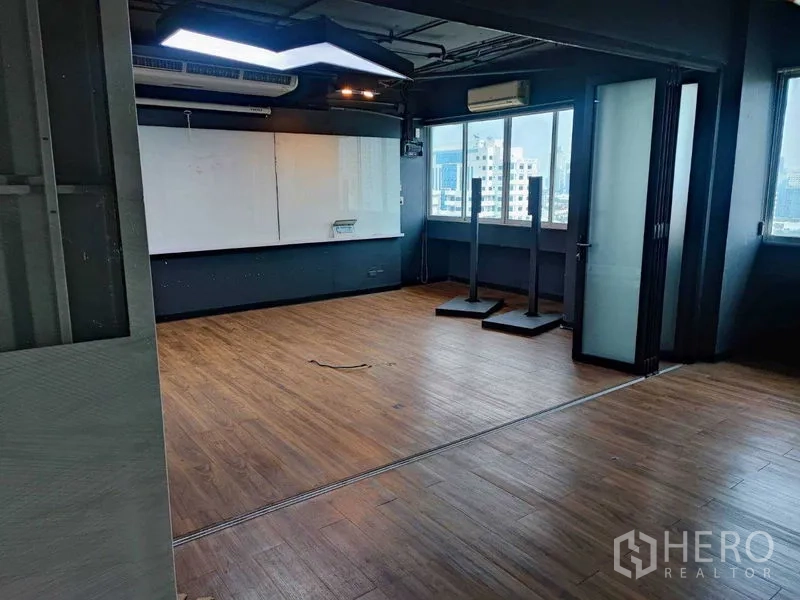 办公空间 出租在Watthana, Bangkok - 开放式办公室，木纹地板、整面白板墙、空调与城市景观窗。