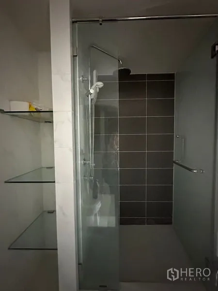 คอนโด ขายในKhlong Toei, Bangkok - ตู้ชาวเวอร์กระจก พร้อมฝักบัวและผนังกระเบื้องสีเทา มีชั้นกระจกวางของ