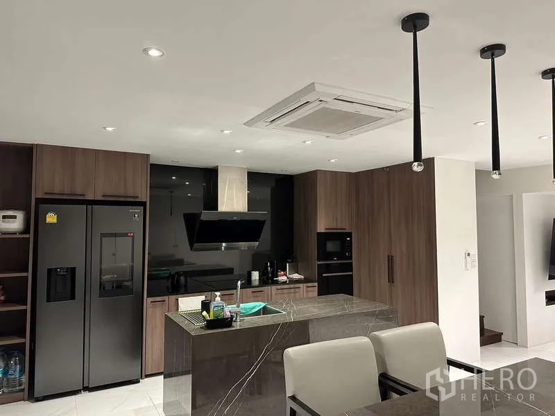 Townhouse for rent in Yan Nawa, Bangkok - Sleek kitchen with island, wood cabinetry and built-in appliances.