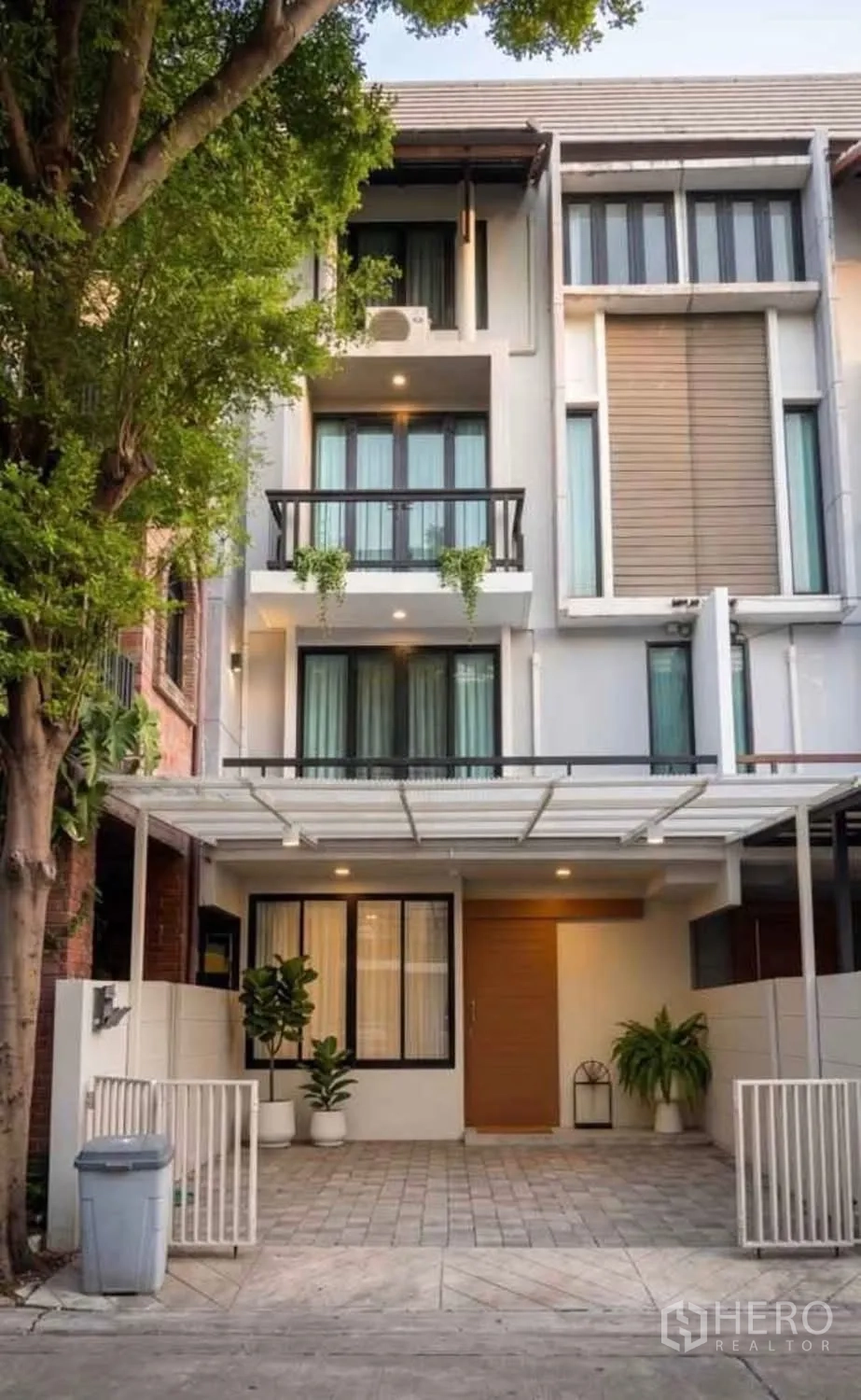 Townhouse for rent in Suan Luang, Bangkok - Contemporary three-storey townhouse exterior with balconies and a covered carport.
