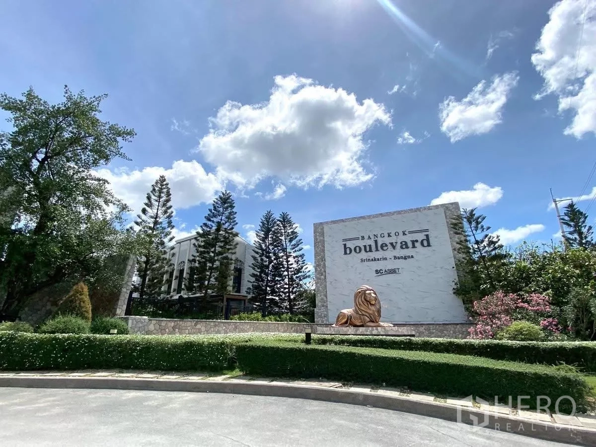 Detached House for rent in Bang Phli, Samut Prakan - Entrance of Bangkok Boulevard Srinakarin–Bangna with project signage and tall trees.