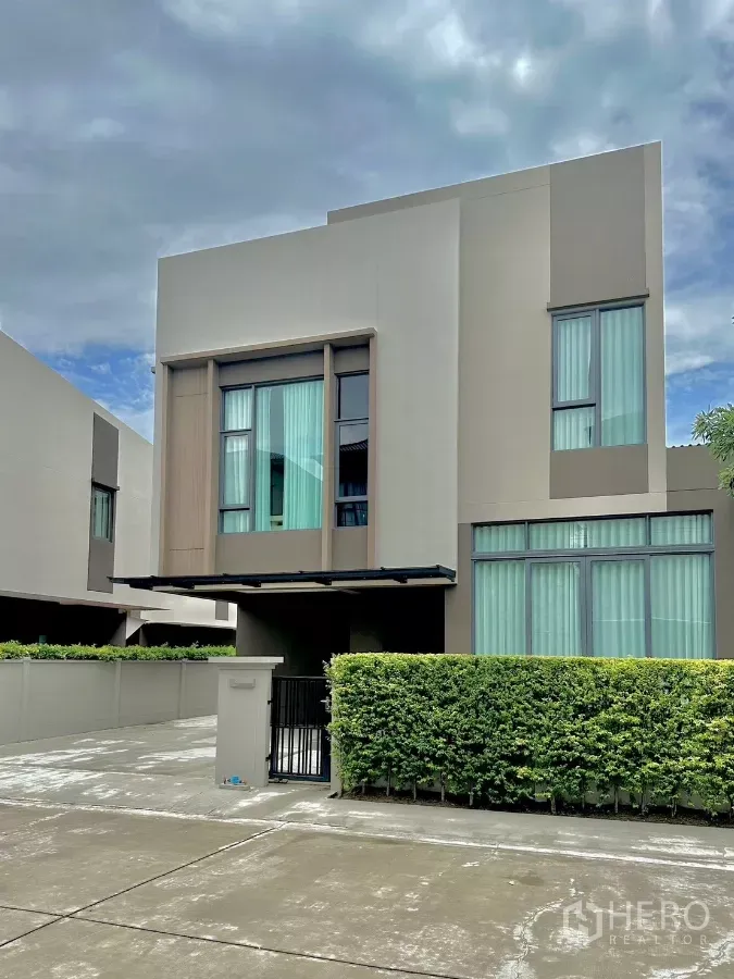 บ้าน ให้เช่าหรือขายในPrawet, Bangkok - ด้านหน้าบ้านเดี่ยวสไตล์โมเดิร์น สูง 2 ชั้น กระจกบานใหญ่ พร้อมที่จอดรถและแนวพุ่มไม้