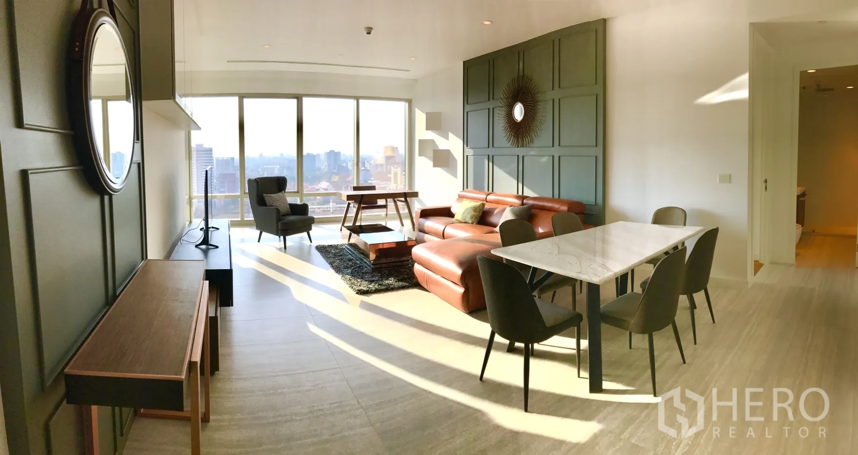 คอนโด ให้เช่าในPathum Wan, Bangkok - ห้องนั่งเล่นและรับประทานอาหารแบบเปิดโล่ง โซฟาหนัง และผนังกระจกสูง