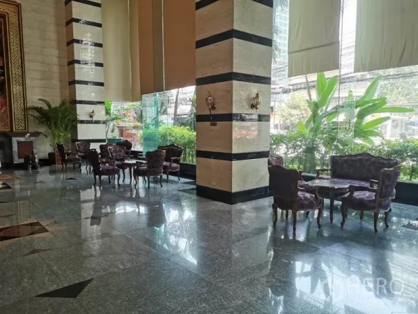 Condominium for rent in Watthana, Bangkok - Elegant lobby with marble floors, striped columns and classic lounge seating by tall windows.