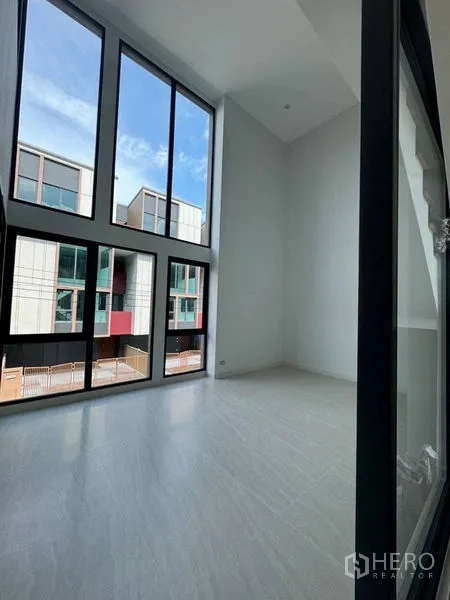Townhouse for rent - Bright room with full-height glazing and urban townhouse views.