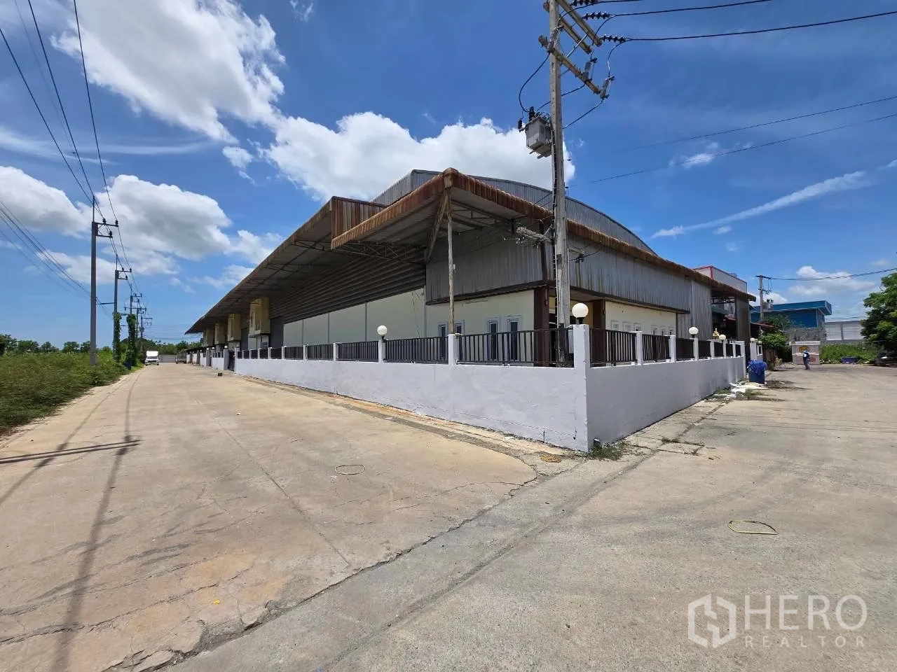 โกดัง for rent or sale in Mueang Samut Sakhon, Samut Sakhon - มุมถนนเห็นรั้วรอบโกดังและถนนทางเข้ากว้าง