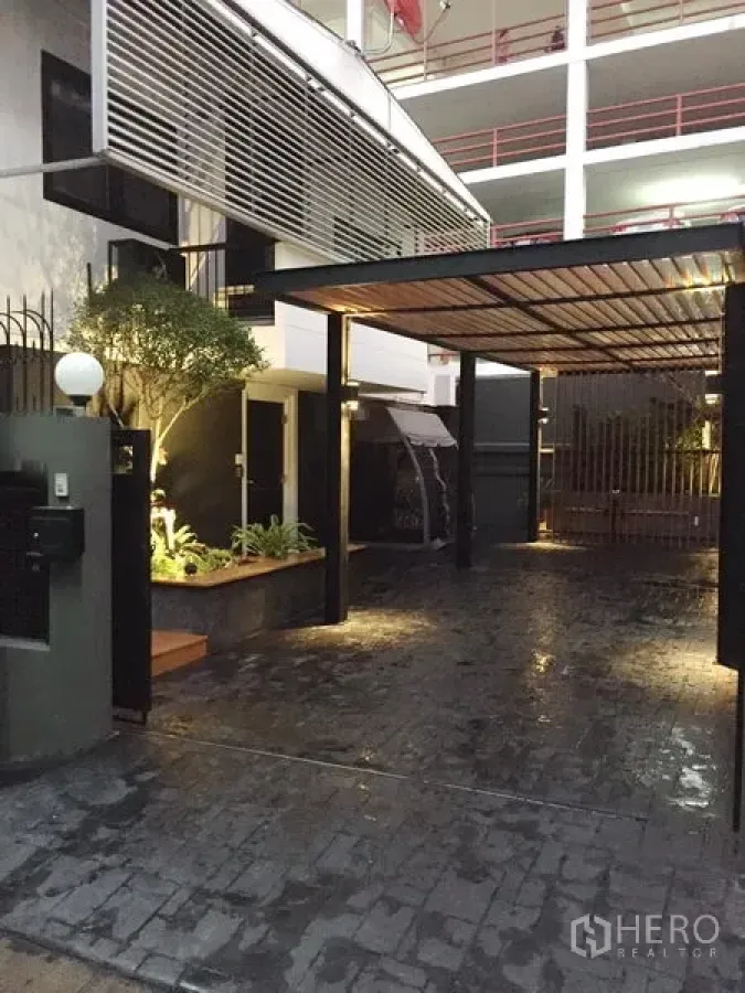บ้าน ให้เช่าในWatthana, Bangkok - ทางเข้าและโรงจอดรถมีหลังคา พร้อมสวนตกแต่งและไฟส่องสว่าง บรรยากาศเอกมัย กรุงเทพฯ