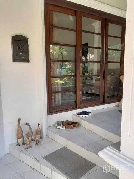 Detached House for rent in Khlong Toei, Bangkok - Front entry steps leading to wooden sliding glass doors of the home.
