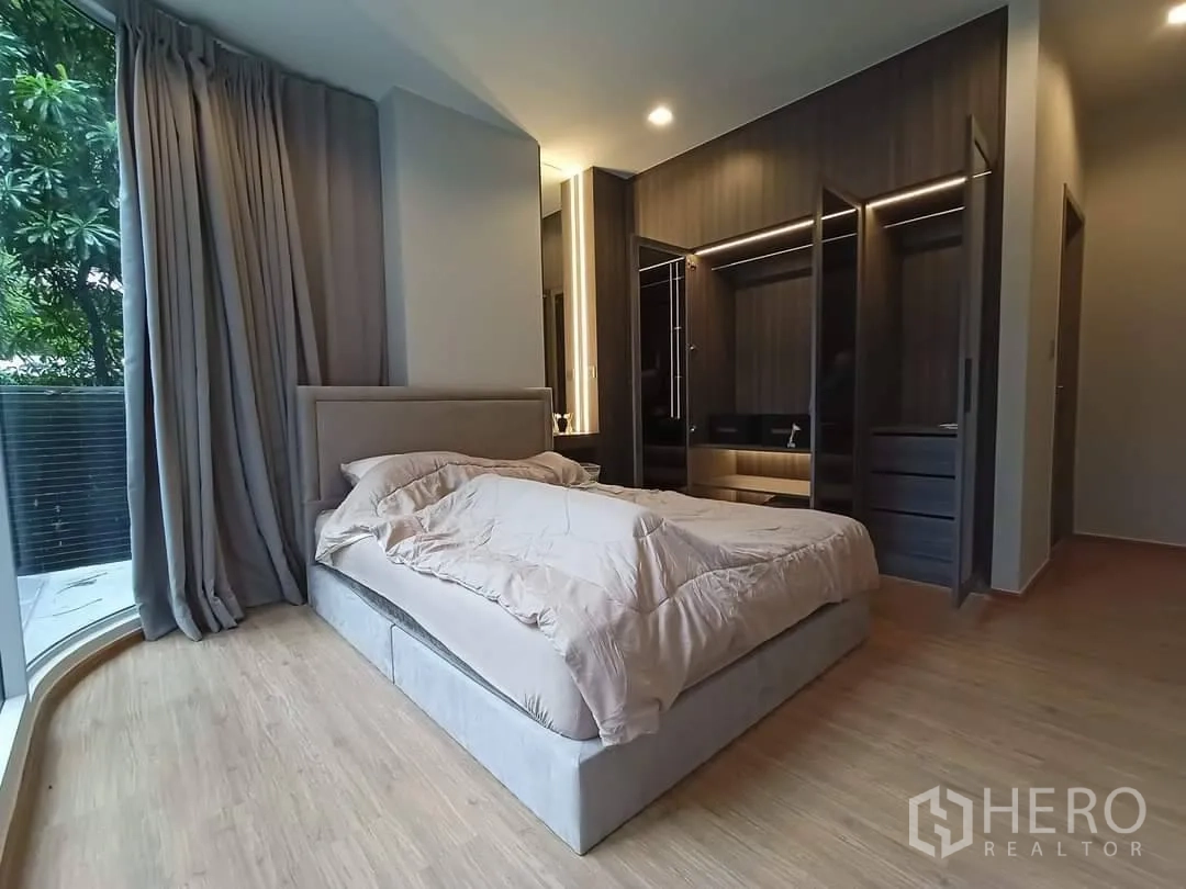 公寓 for rent in Watthana, Bangkok - 主卧带嵌入式衣柜与弧形窗户，景观绿意