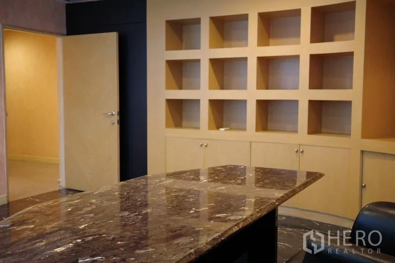 Office Space for rent in Bang Na, Bangkok - Meeting room with a polished marble conference table and display shelving.