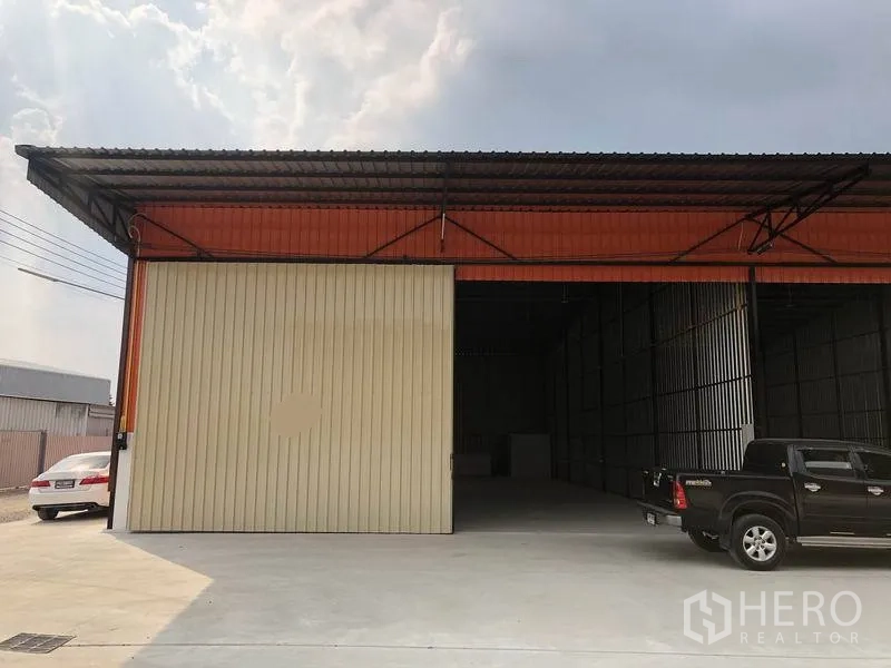คลังสินค้า ให้เช่าในPathum Thani - ด้านหน้าโกดัง ประตูเหล็กบานเลื่อนกว้าง หลังคากันสาดและที่จอดรถ