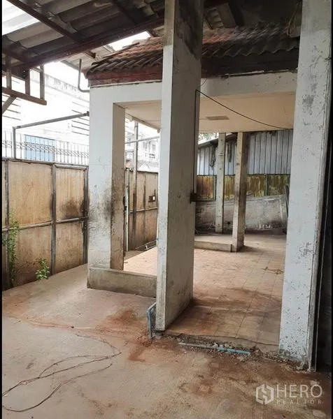 Warehouse for rent in Phra Samut Chedi, Samut Prakan - Roofed side yard with concrete columns and tiled floor suitable for utility or storage use.