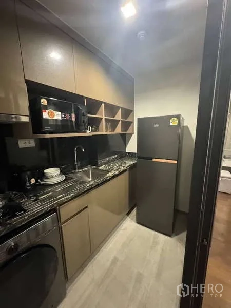 คอนโด ให้เช่าในKhlong Toei, Bangkok - ครัวแบบแกลลี่ท็อปหินลาย พร้อมอ่างล้างมือ ตู้เย็น ไมโครเวฟ และเครื่องซักผ้า