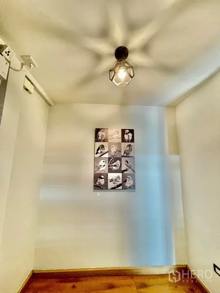 Townhouse for rent in Khlong Toei, Bangkok - Small foyer nook with pendant light and framed artwork on the wall.