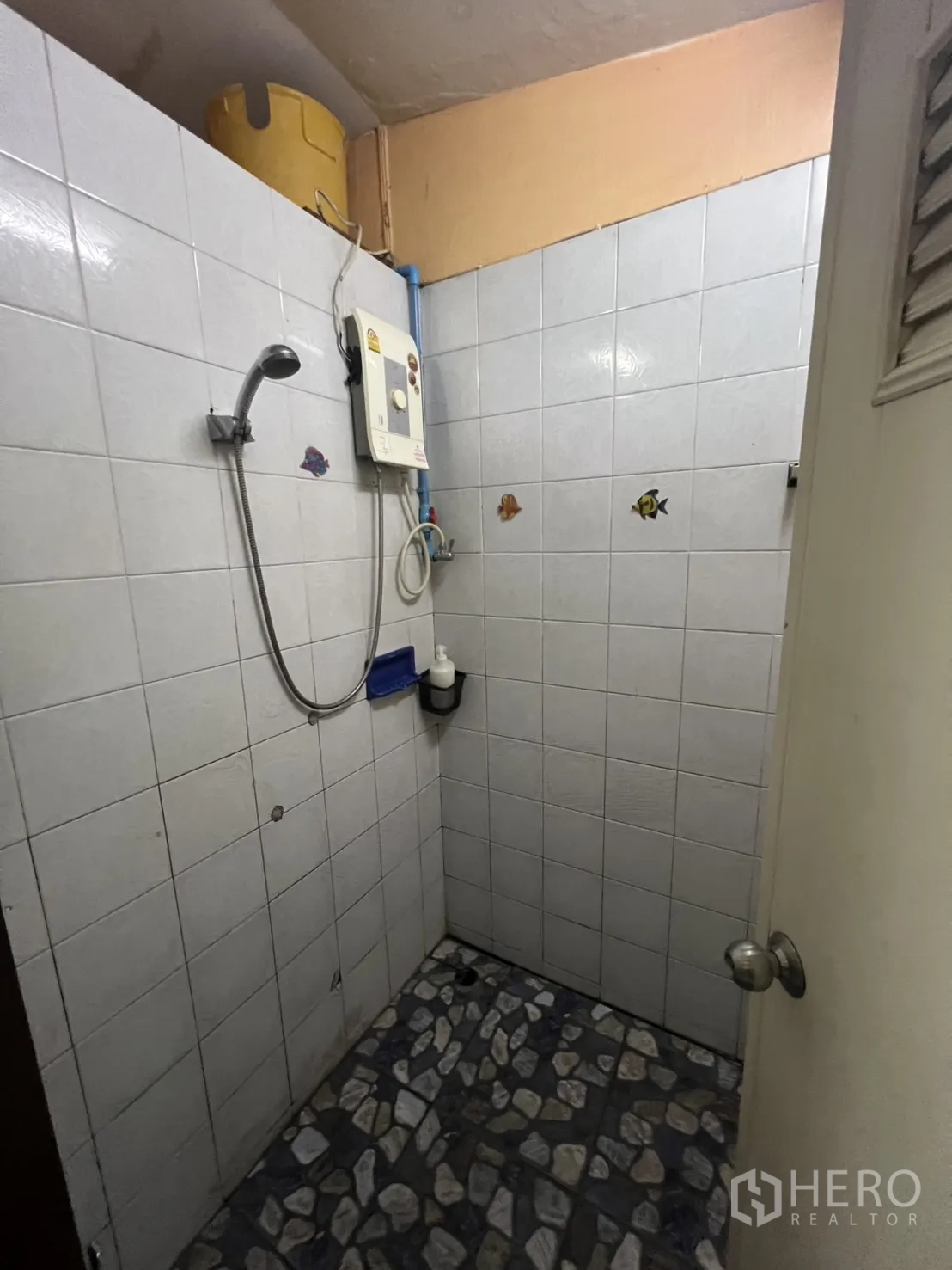อาคารพาณิชย์ ให้เช่าในKhlong Toei, Bangkok - พื้นที่อาบน้ำพร้อมเครื่องทำน้ำอุ่นและผนังกระเบื้องสีอ่อน.