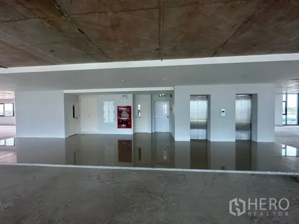 สำนักงาน ให้เช่าในBang Phli, Samut Prakan - โถงลิฟต์สำนักงาน ลิฟต์สแตนเลสสองตัว ตู้สายฉีดน้ำดับเพลิง และพื้นเงา