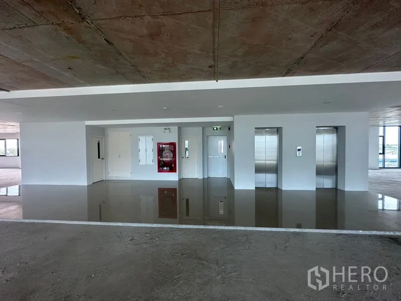 สำนักงาน ให้เช่าในBang Phli, Samut Prakan - โถงลิฟต์สำนักงาน ลิฟต์สแตนเลสสองตัว ตู้สายฉีดน้ำดับเพลิง และพื้นเงา