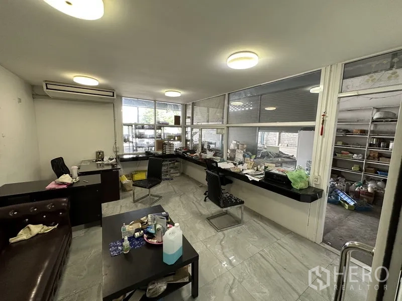 Warehouse for sale in Bang Khen, Bangkok - Glass-partition office inside the warehouse with desks and air-conditioning.