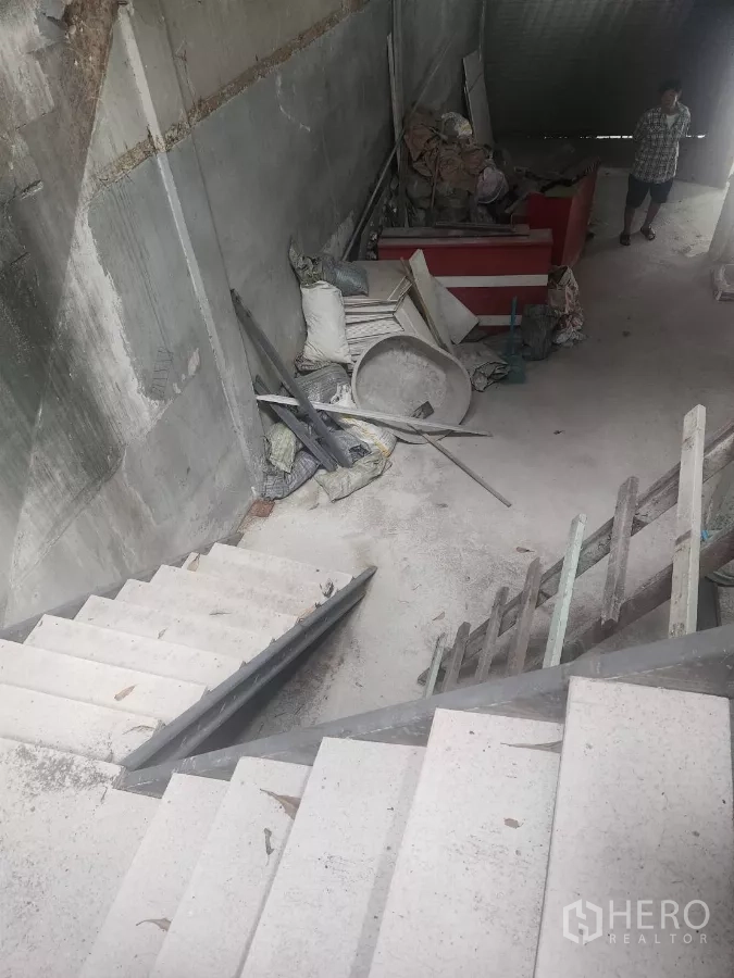 店屋 出租在Watthana, Bangkok - 混凝土楼梯与未完工室内，散放施工材料