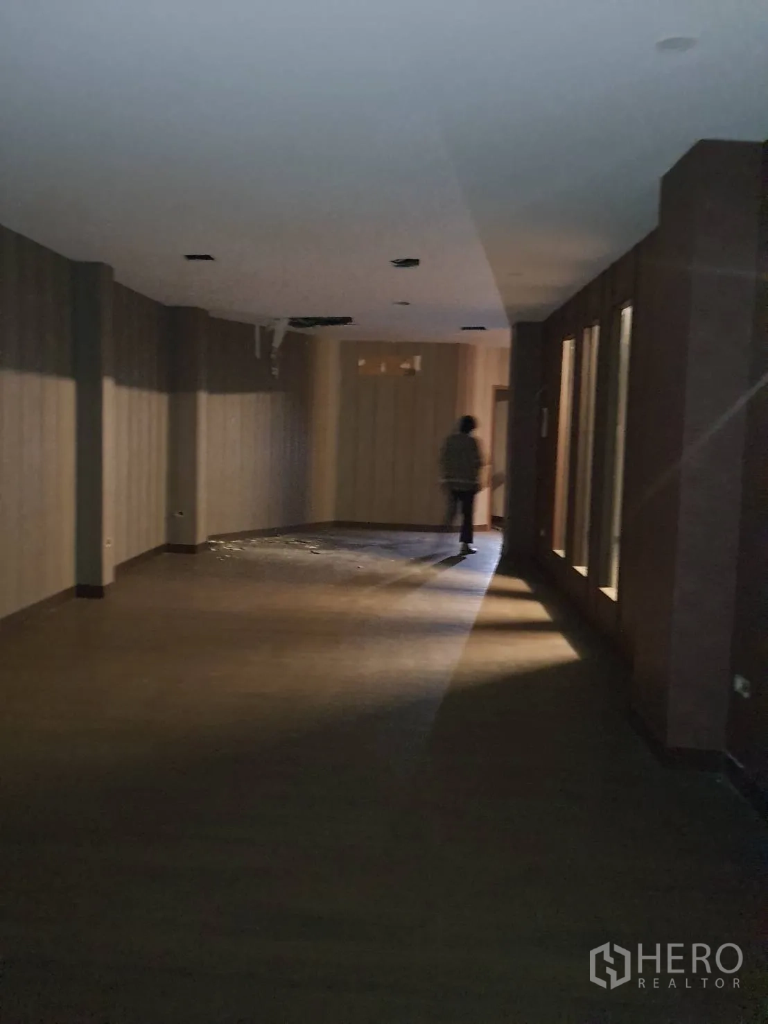 Shophouse for rent in Khlong Toei, Bangkok - Deep open-plan space with dark wood flooring and recessed ceiling lights, suitable for showroom layout.