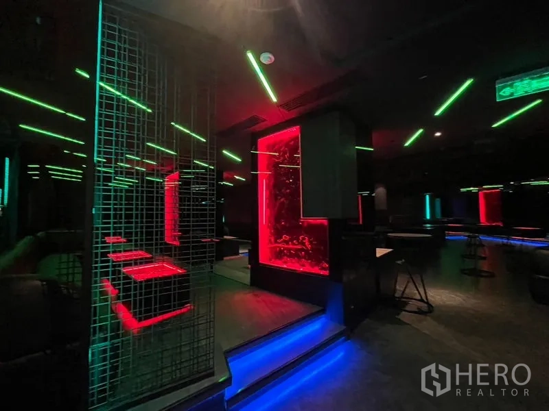 零售空间 出租在Ratchathewi, Bangkok - 室内可见红色装饰面板、金属网隔断与蓝色地灯。